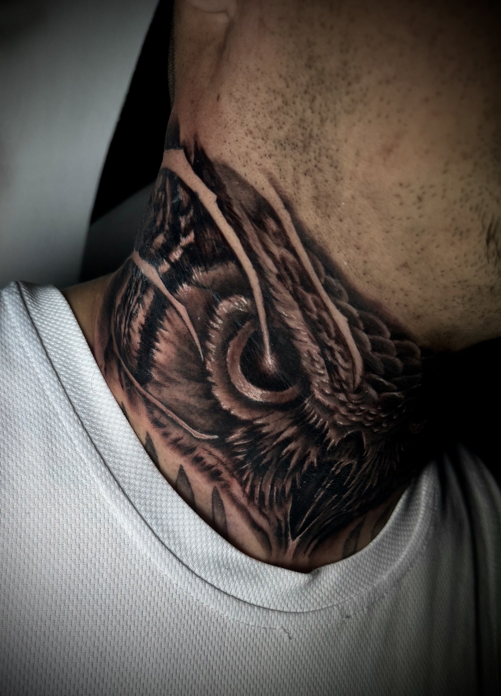 Búho realista tatuado en el cuello